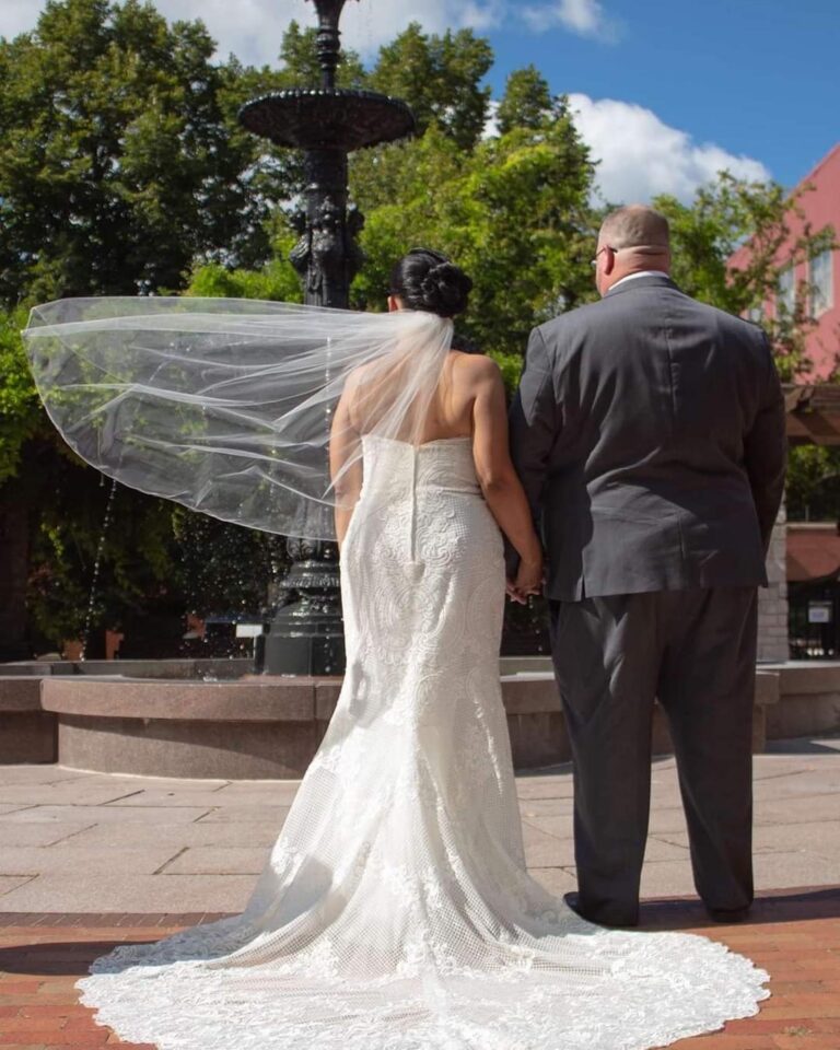 wedding photo of bride and groom looking at fountain